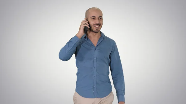 Młody arabski człowiek chodzenie i rozmawianie przez telefon i uśmiech na gra — Zdjęcie stockowe