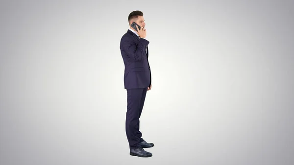 Uomo d'affari che parla al telefono su sfondo sfumato. — Foto Stock