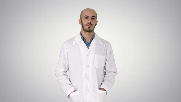 Árabe guapo médico vistiendo su uniforme caminando con las manos en p — Foto de Stock