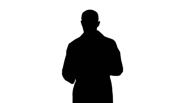 Silhouette Médico masculino maduro sosteniendo la tableta digital usándola y caminando. — Foto de Stock
