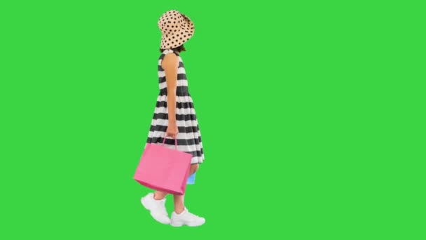 Petite fille mignonne marchant avec des sacs à provisions sur un écran vert, Chroma Key. — Video