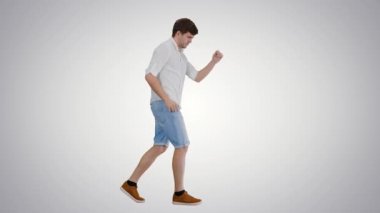 Gayri ihtiyari giyinmiş genç adam, arka planda yürürken mutlu bir şekilde dans ediyor..