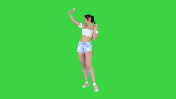 Gyönyörű fiatal nő csinál szelfi egy zöld képernyőn, Chroma Key. — Stock videók