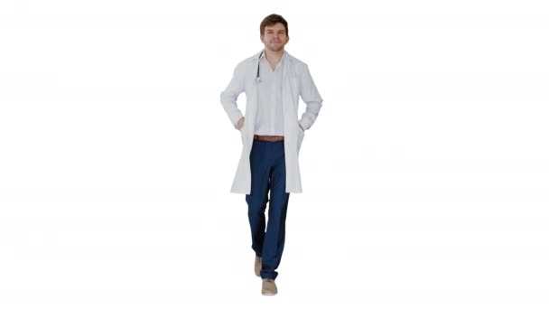 Médico masculino de bata blanca caminando con las manos en los bolsillos mirando hacia adelante sobre fondo blanco. — Vídeos de Stock