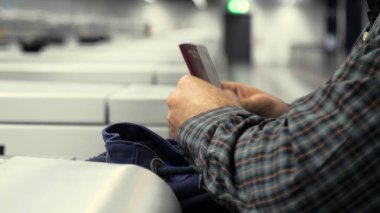 Havaalanına giriş yapan adam, pasaportunu sırt çantasından alıyor ve giriş için veriyor..