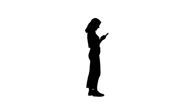 Силуэт Случайная молодая женщина, печатающая на мобильный телефон. — стоковое фото
