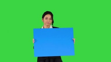 Yeşil Ekran 'da dans eden ve boş poster tutan şık bir kadın, Chroma Key.