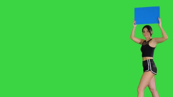 Anello ragazza a piedi tenendo bordo vuoto che presenta nuovo giro su uno schermo verde, Chroma Key. — Video Stock
