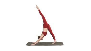 Kırmızı spor giyimli güzel bir kadın yoga ya da pilat yapıyor.