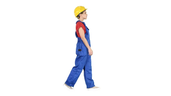 Mujer joven trabajadora de la construcción en hardhat amarillo caminando sobre whi —  Fotos de Stock