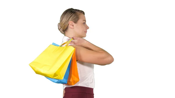 Jovem mulher feliz com sacos de compras andando sobre fundo branco — Fotografia de Stock