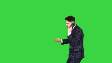 Resmi takım elbiseli kızgın genç adam yeşil ekranda dans ettikten sonra telefonda konuşuyor, Chroma Key.