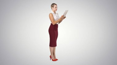 Güzel, modern bir kadın, gradyan arka Grou üzerinde dijital tablet kullanıyor.