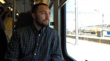 Genç adam trene binerken pencereden dışarı bakıyor..