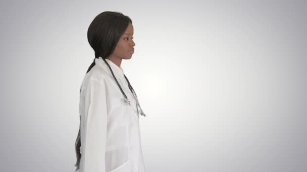 Sorglig afroamerikansk kvinnlig läkare går med händerna i fickorna på lutning bakgrund. — Stockvideo