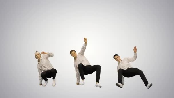 Три парня танцуют брейк-данс синхронно, смотрят в камеру на градиентном фоне. — стоковое видео