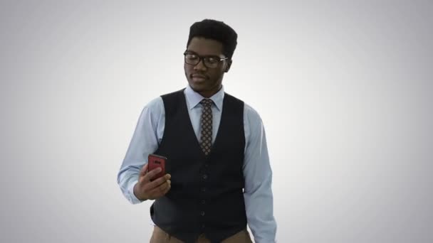 African american businessman making selfies with his phone while walking on gradient background. — Stock Video