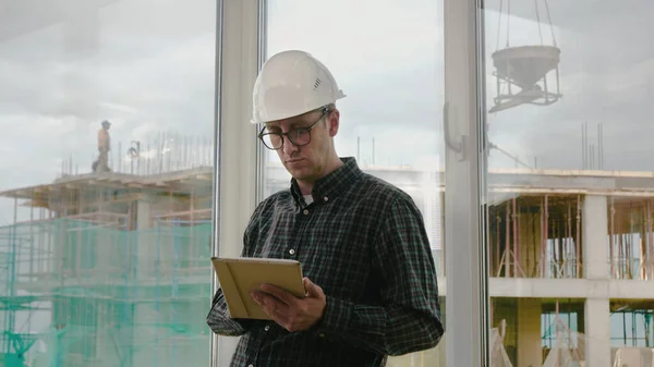 Inženýr pracující na tabletu v ruce na staveništi. — Stock fotografie