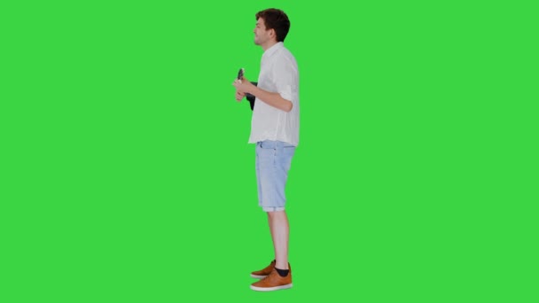 Jovem sorrindo jogando ukulele olhando para a câmera em uma tela verde, Chroma Key. — Vídeo de Stock