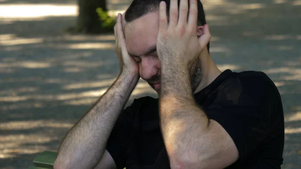 Άντρας με κουρασμένη και άρρωστη έκφραση σε ένα πάρκο — Φωτογραφία Αρχείου
