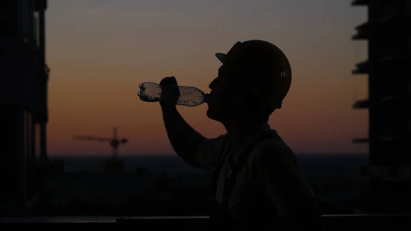 Будівельник п'є з пляшки . — стокове фото