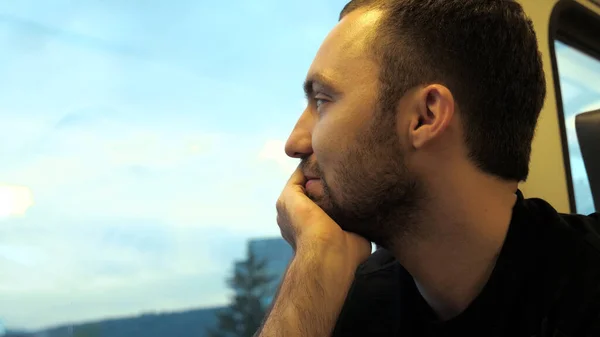 Uomo attraente con la barba che viaggia in treno. Bello giovane maschio guardando la finestra e pensando. — Foto Stock