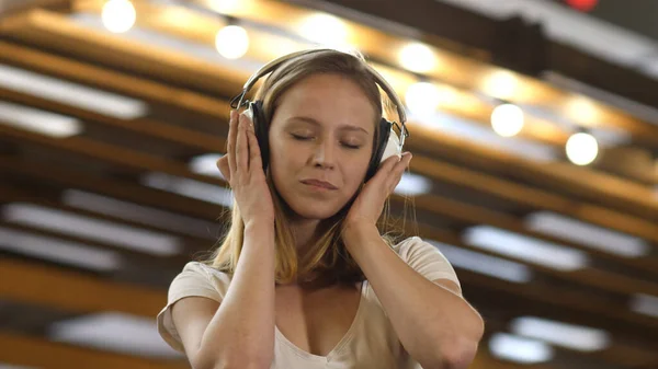 Menina moderna bonito adolescente com fones de ouvido ouvindo música. — Fotografia de Stock