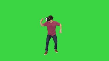 Yeşil Ekran, Chroma Key 'de sanal gerçeklik dünyasına dokunan ve etkileşen VR kulaklık kullanan inanılmaz bir adam..