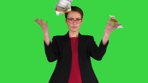 Деловая женщина в очках бросает деньги в воздух на зеленый экран, Chroma Key. — стоковое видео