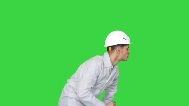 Ung arbejder med hjelm i hvid kåbe nyder at danse på en grøn skærm, Chroma Key. – Stock-video