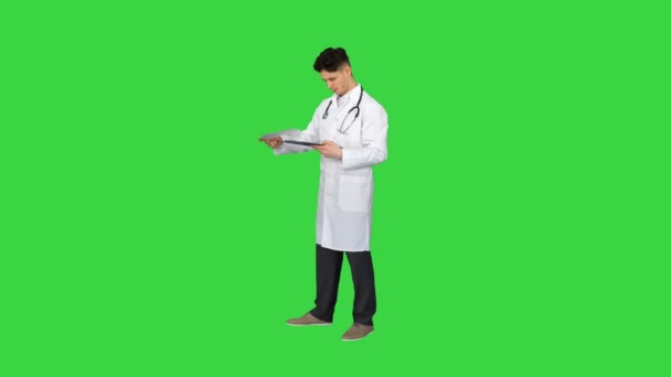 Zły lekarz patrząc na dokumenty na zielonym ekranie, Chroma Key. — Wideo stockowe