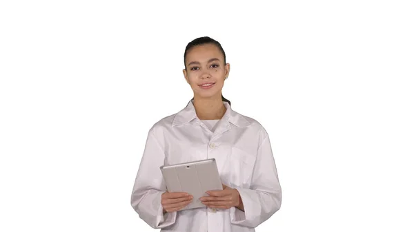 Feliz médico femenino usando la tableta de la computadora deslizando páginas en él —  Fotos de Stock