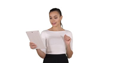 Mutlu bir kadın beyaz bir grupta, tablet üzerinden görüntülü konuşma yapıyor.