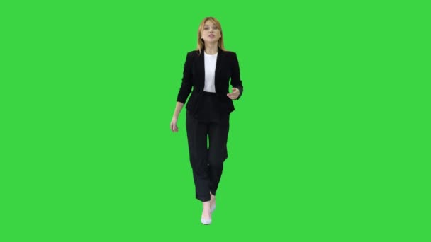 Όμορφη νεαρή γυναίκα με επίσημη στολή περπάτημα και μιλώντας με την κάμερα σε μια πράσινη οθόνη, Chroma Key. — Αρχείο Βίντεο