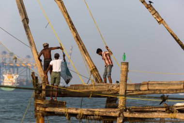 Kochin, Hindistan-Şubat 24: Balıkçılar üzerinde 24 Şubat 2013 Kochin, Hindistan'da şehir noktasında. Hint balıkçı balıkçılık için geleneksel Çince ağ kullanma