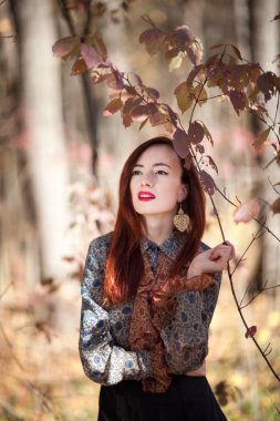 Genç ince kırmızı sonbahar kız sonbahar ormanda poz