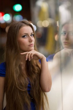 Güzel kız gece şehrin sokak dükkanı penceresinde arıyorum