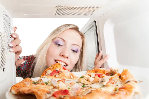 Genç Güzel Sarışın Kız Mikrodalgada Pizza Yemek — Stok fotoğraf