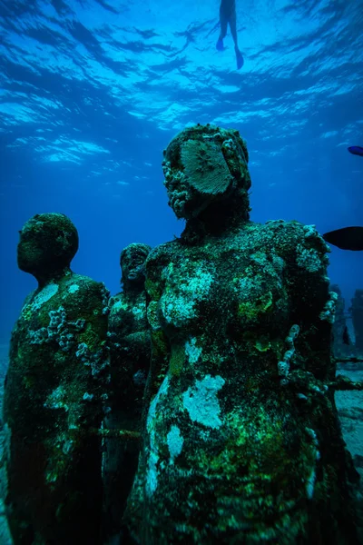 underwater picture of stone statues on ocean bottom