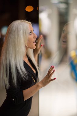 Güzel mavi gözlü kız shopwindow gece şehrin sokak üzerinde seyir