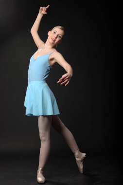 Güzel genç sarışın balerin siyah arka plan üzerinde dans 