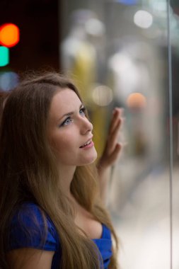 Güzel kız gece şehrin sokak dükkanı penceresinde arıyorum