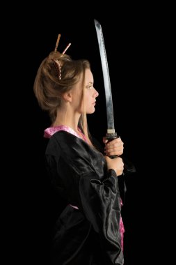 Bir katana tutan bir Japon kimono güzel yeşil gözlü kız. Siyah arka plan üzerine izole
