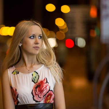 Genç ve güzel sarışın kız bir gece şehirde sokak yürüyüş