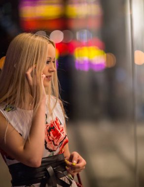 Güzel kız gece şehrin sokak dükkanı penceresinde arıyorum