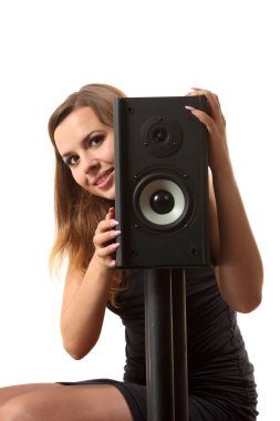 Beyaz izole arka planda bir hoparlör yakınındaki bir genç kız