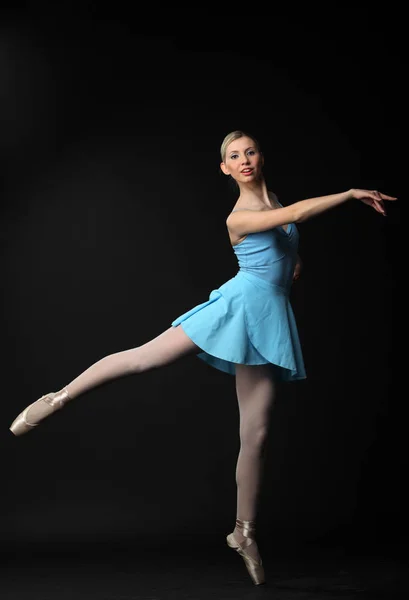 美丽的年轻金发碧眼的芭蕾舞演员在黑色的背景跳舞 — 图库照片