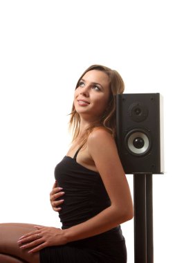 Beyaz izole arka planda bir hoparlör yakınındaki bir genç kız