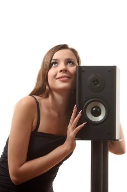 Beyaz izole arka planda bir hoparlör yakınındaki bir genç kız