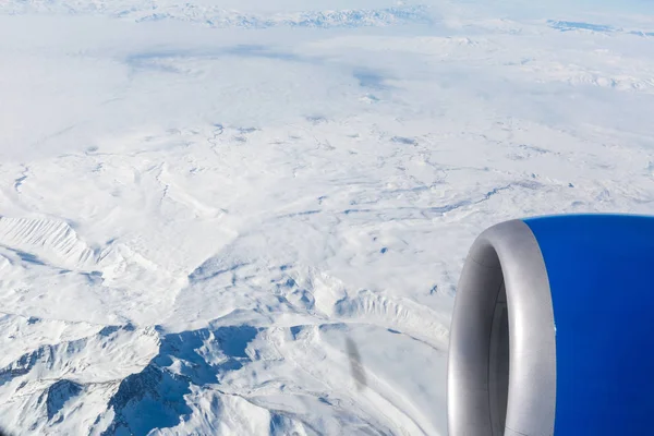 飛行機の窓から雪に覆われた山々 — ストック写真